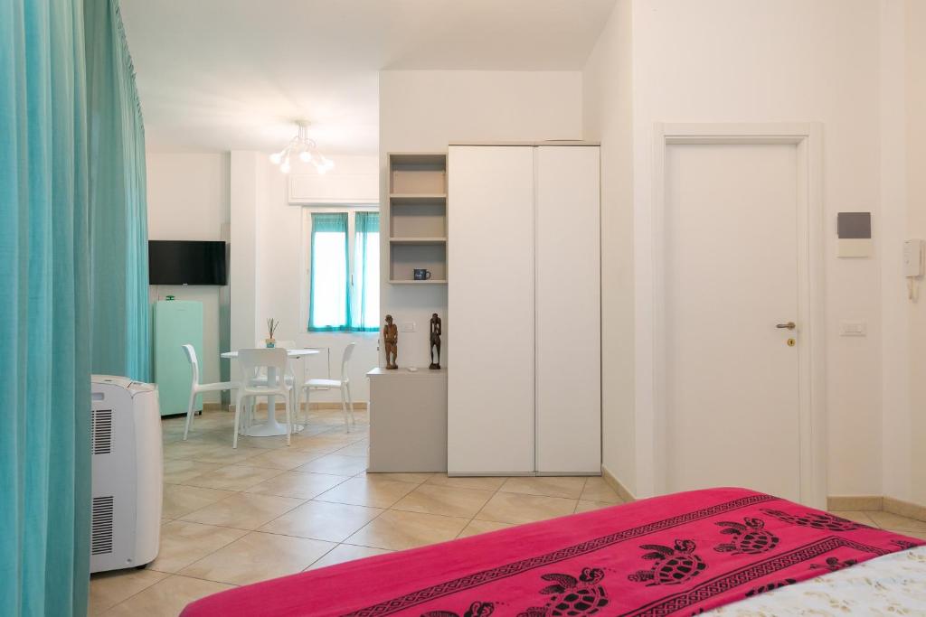 een slaapkamer met een bed en een keuken met een tafel bij Casa dell'elba in Piombino