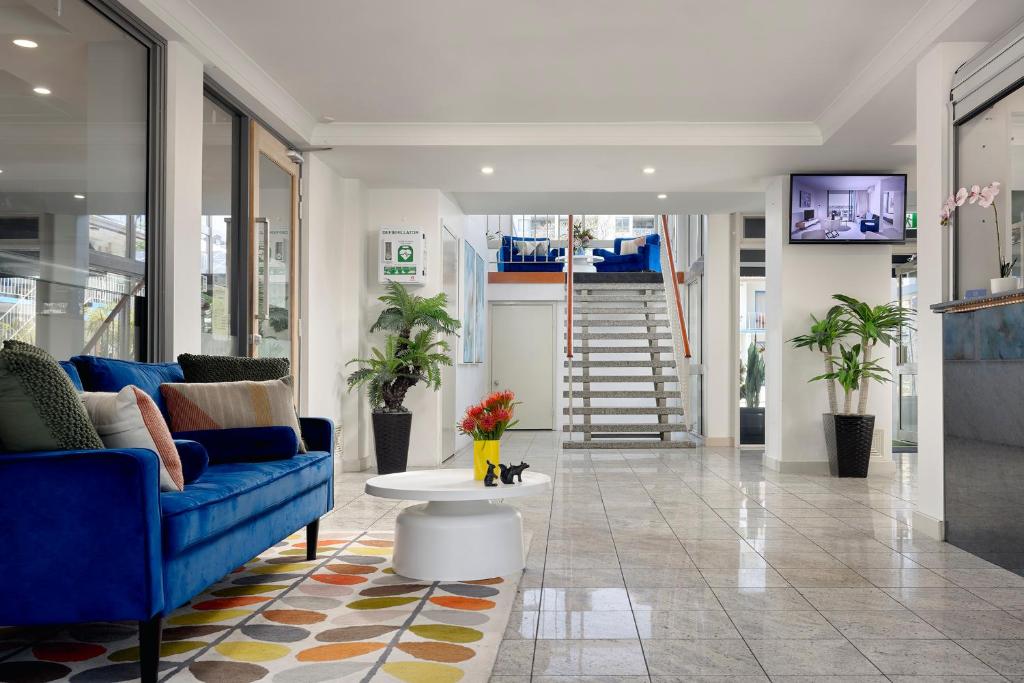 vestíbulo con sofá azul y mesa en Baileys Parkside Motel by VetroBlu en Perth