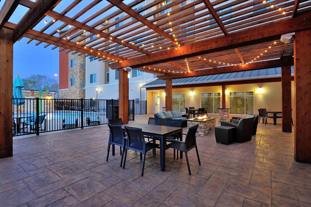 eine Terrasse mit einer hölzernen Pergola sowie einem Tisch und Stühlen in der Unterkunft Residence Inn by Marriott Houston Tomball in Tomball