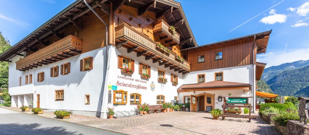 a building in the mountains with mountains in the background at Landgasthof Seisenbergklamm in Weissbach bei Lofer