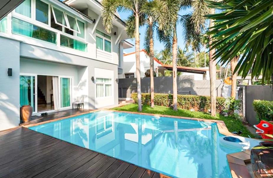 una piscina nel cortile di una casa con palme di Poolvillapanwa a Panwa Beach
