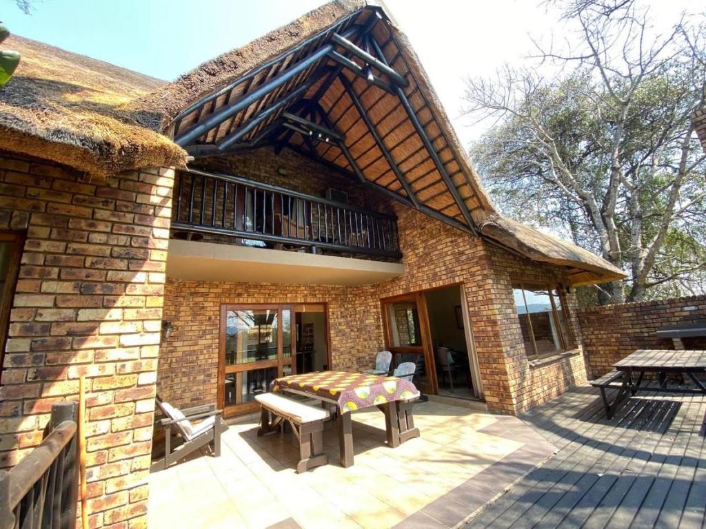 a brick building with a patio with a table and a balcony at Kruger Park Lodge - Private Villa 514 in Hazyview