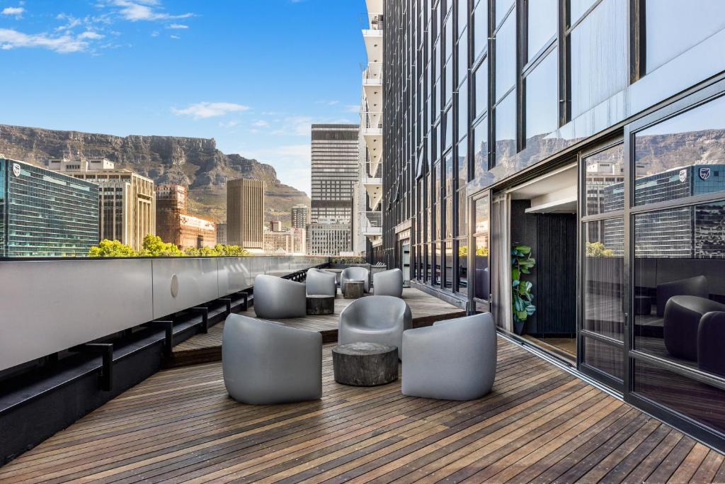 a balcony with chairs and tables on a building at Stylish City Living in Cape Town