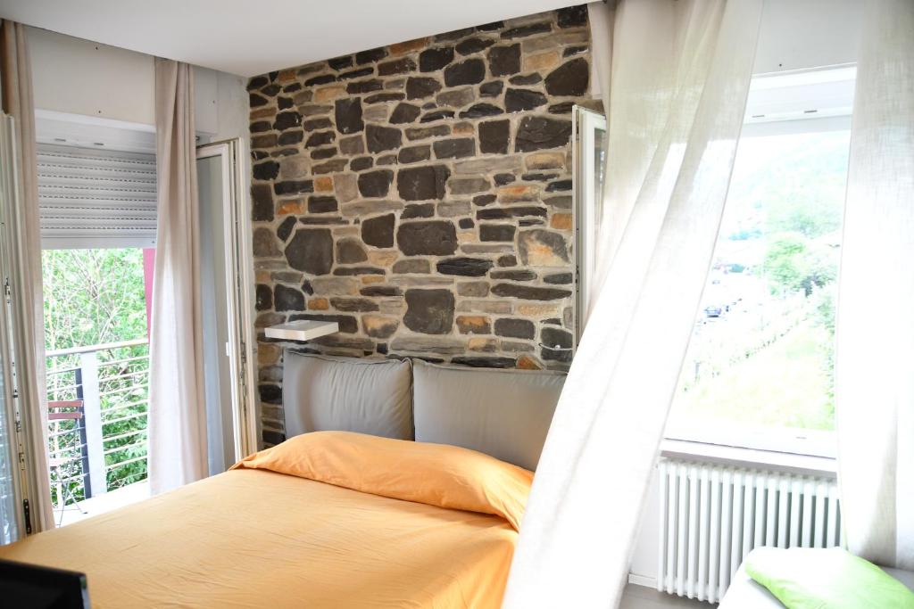 Posto letto in camera con parete in pietra. di Smile accomodation Winter time ad Aosta