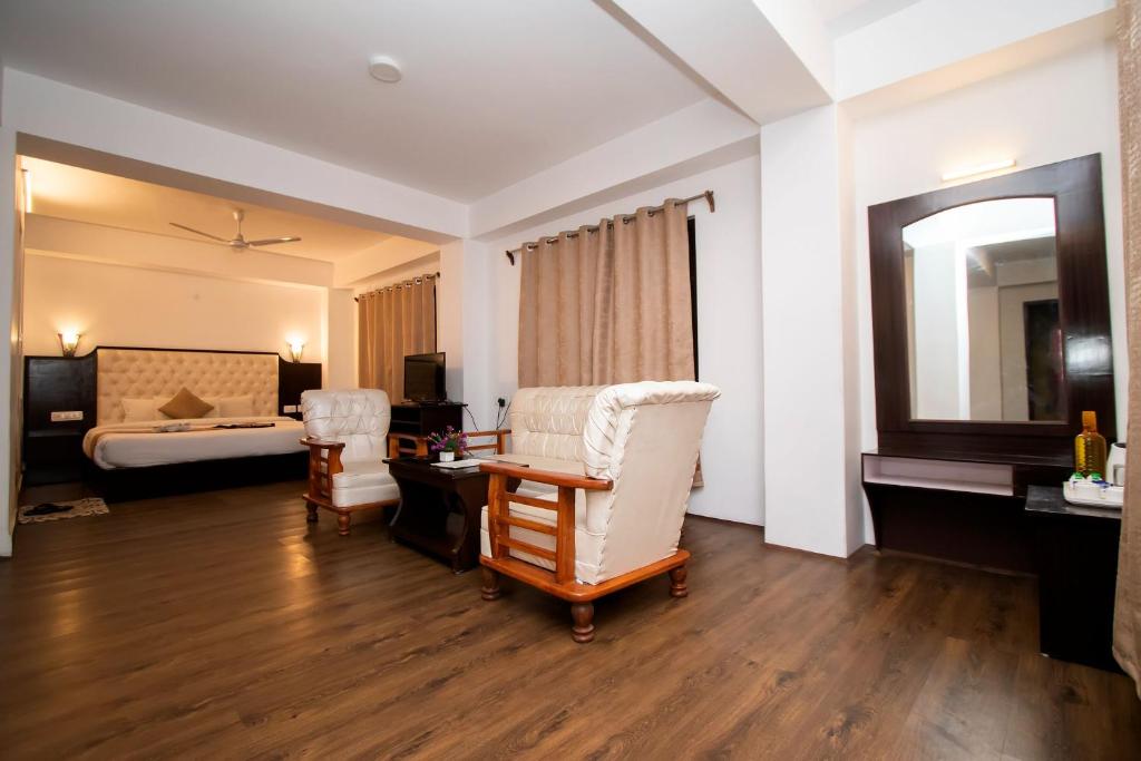 a hotel room with a bed and a desk and chairs at Tiara Regency Gangtok in Gangtok