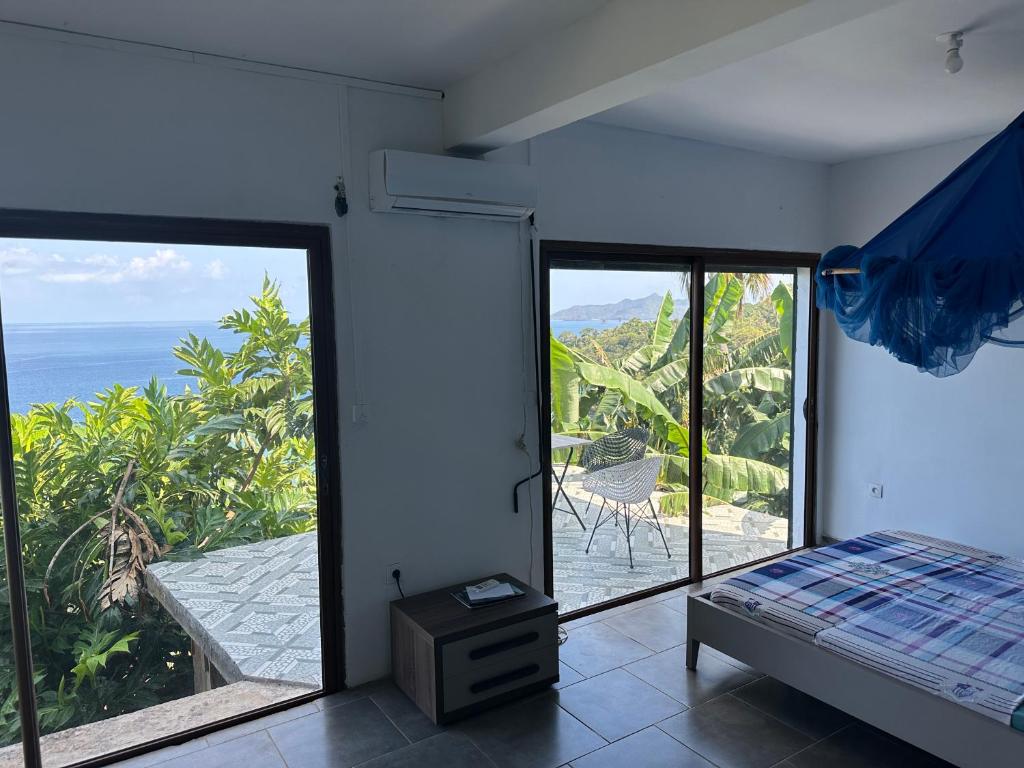 a bedroom with a bed and a view of the ocean at la maison du nord in Acoua