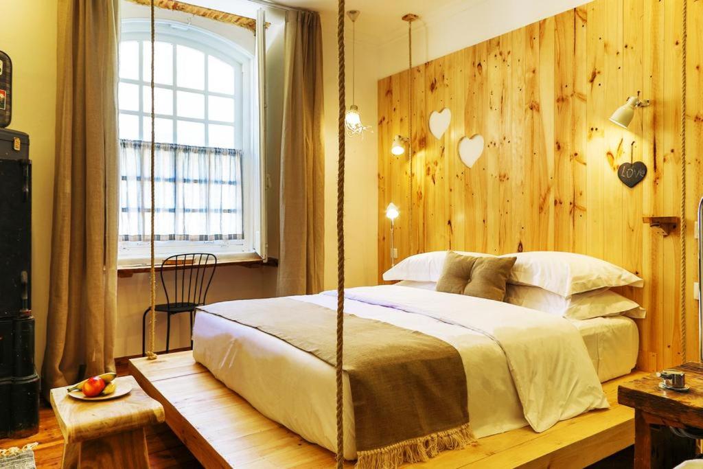 een slaapkamer met een schommelbed en een raam bij 262 Boutique Hotel in Lissabon