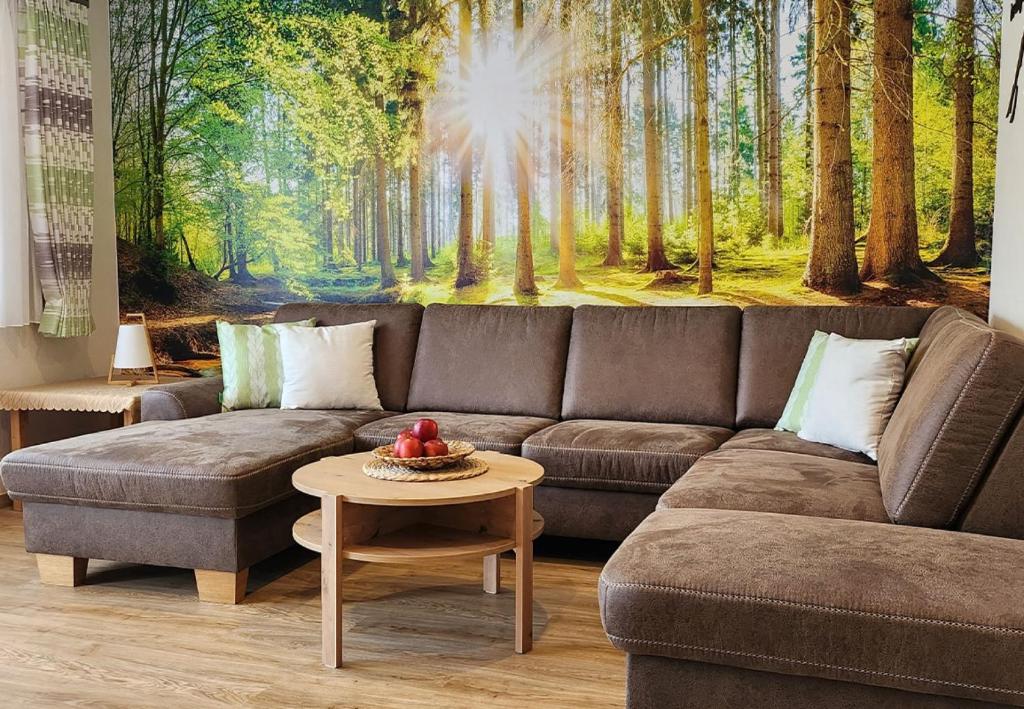 sala de estar con sofá y mural forestal en Gästehaus Nietmann_ Ferienwohnung 8, en Altenau