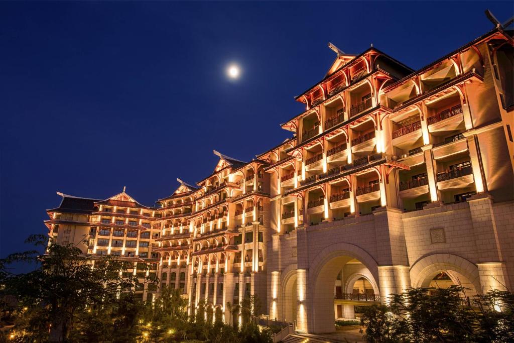 ein großes Gebäude in der Nacht mit einem Mond am Himmel in der Unterkunft Haikou Marriott Hotel in Haikou