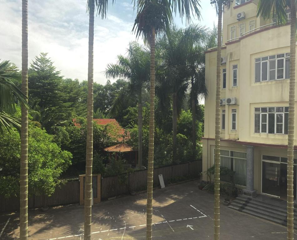 a building with palm trees in front of it at Khách sạn Phương Đông in Hải Dương