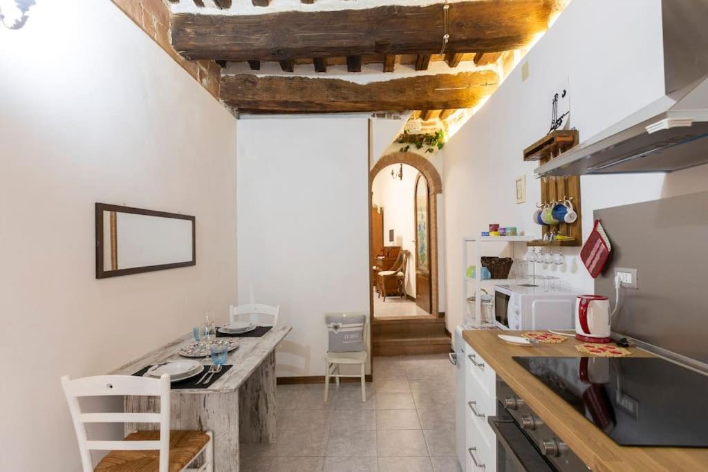 cocina con electrodomésticos blancos y techo de madera en Casa Onda - nel cuore della contrada, en Siena