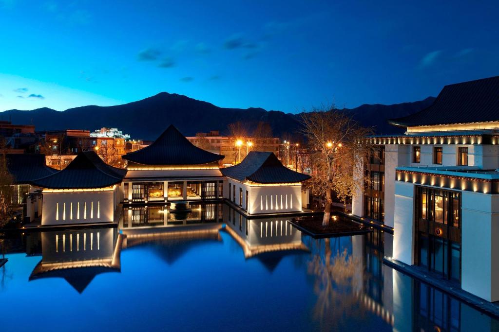 The St. Regis Lhasa Resort في لاسا: اطلالة على مبنى في الليل