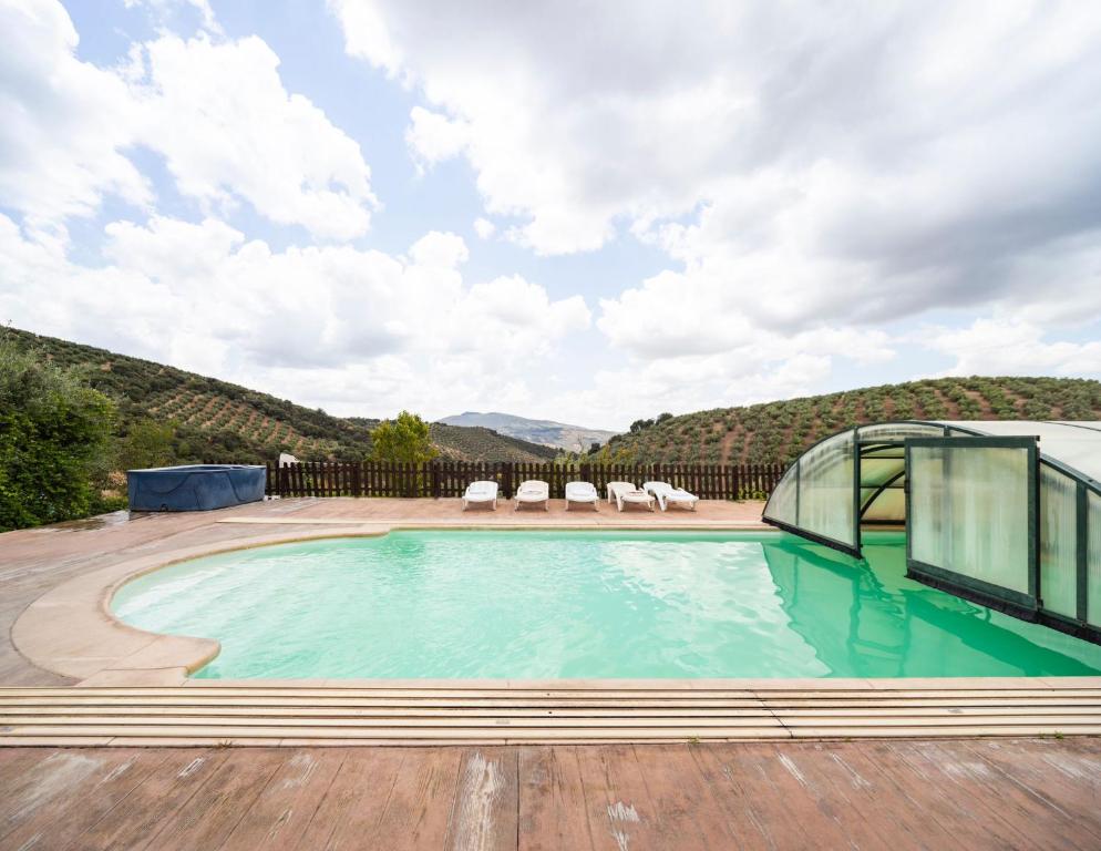 uma piscina com vista para uma montanha em La Pedriza del Serval em Montefrío