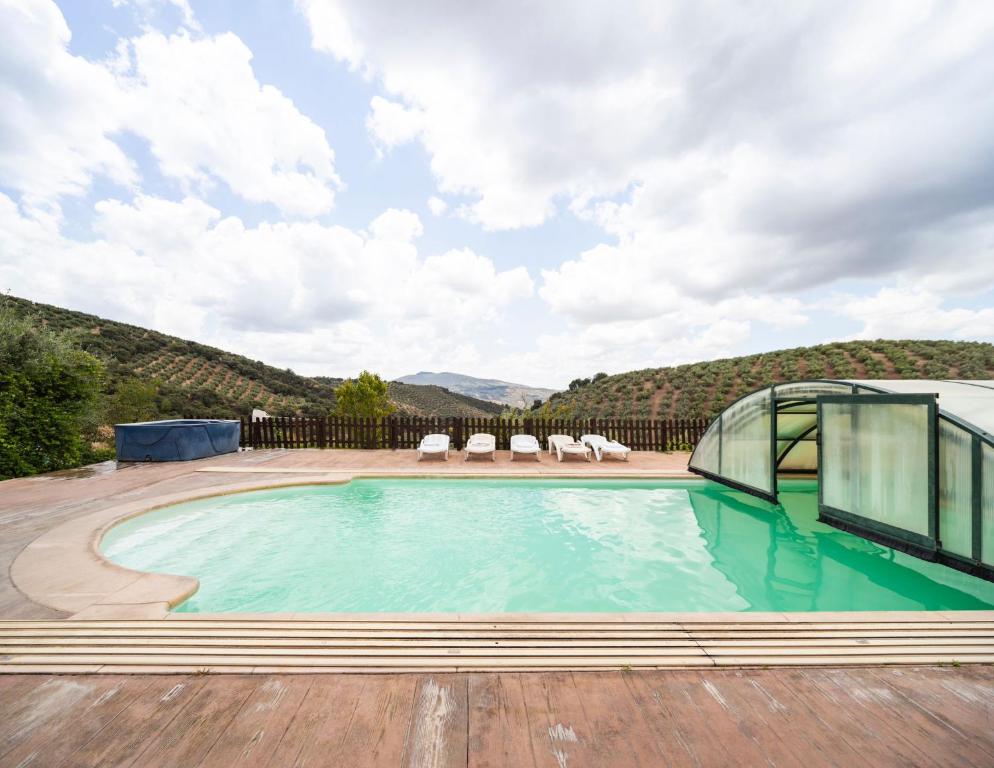 a swimming pool with a view of a mountain at La Pedriza del Serval in Montefrío