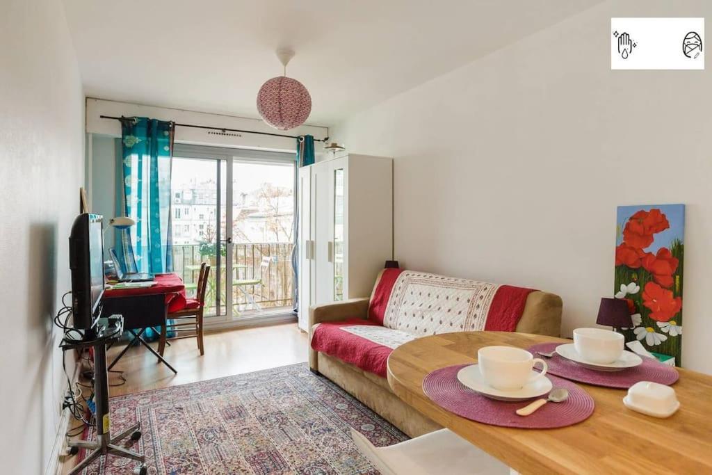un salon avec un canapé et une table dans l'établissement Cozy Studio Bastille with balcony, à Paris