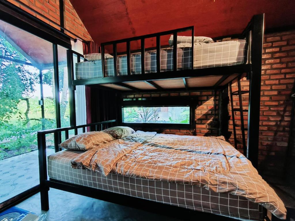- une chambre avec des lits superposés dans un mur en briques dans l'établissement Farm Hug Aai Yam Boutique Homestay, 
