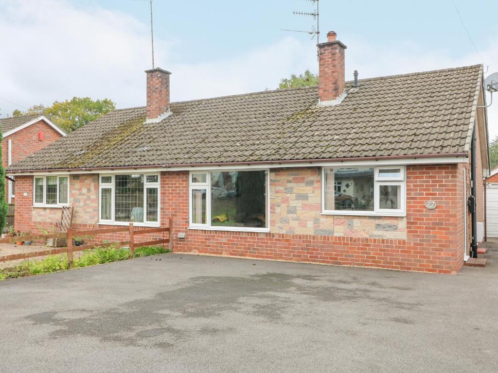 a red brick house with a parking lot at George's Place in Froghall