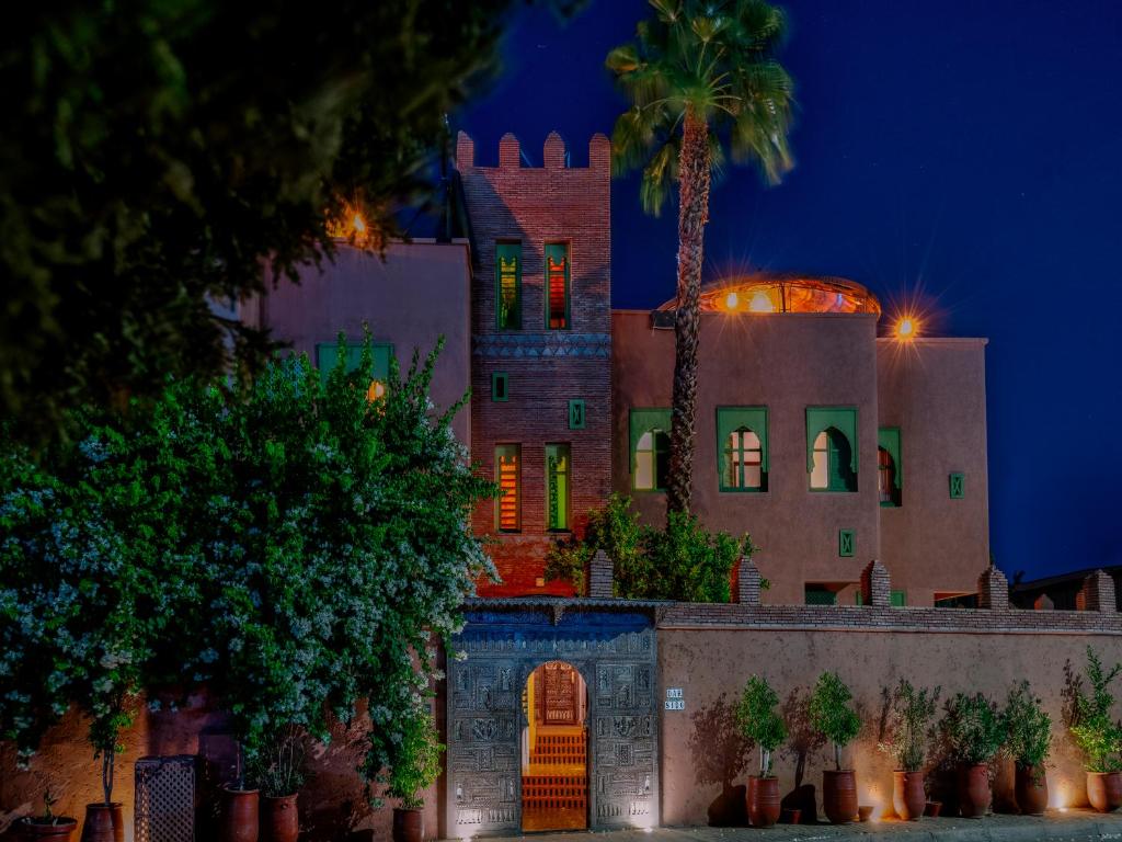 un edificio con una palmera delante de él en Riad Dar Sido, en Marrakech