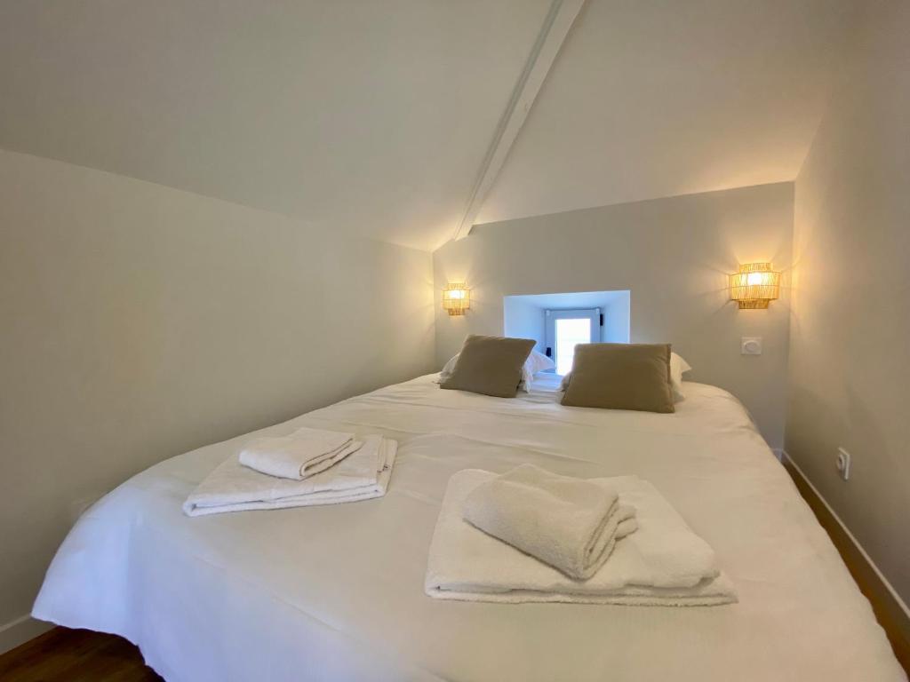 a white bed with two towels on top of it at Le LOUIS 16 - Maison avec jardin in Valence