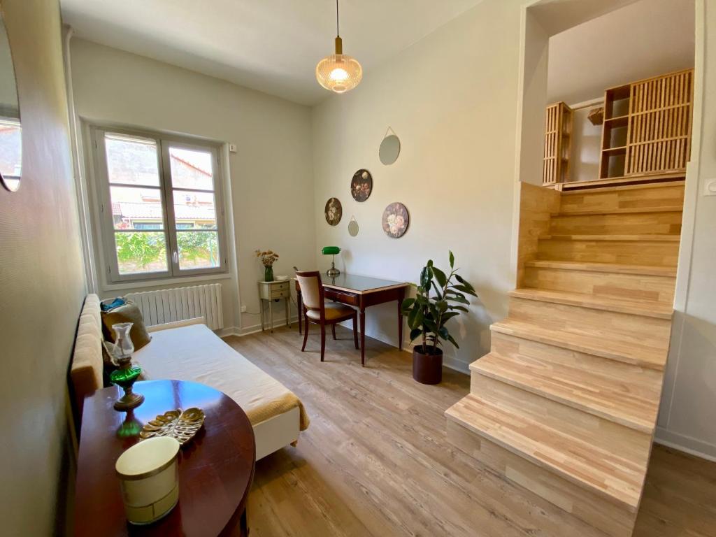 a living room with a staircase and a table at Le LOUIS 16 - Maison avec jardin in Valence