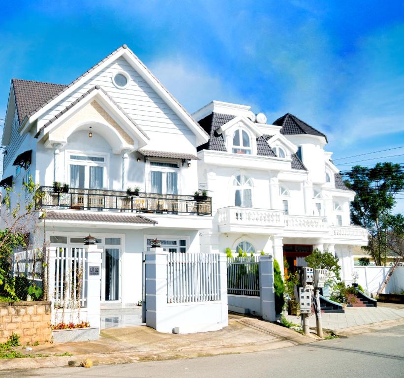 a white house with a gate in front of it at Môn Bạc Home in Da Lat