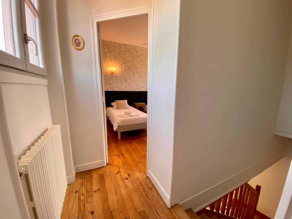 a hallway with a bedroom with a bed in a room at Le LOUIS 16 - Maison avec jardin in Valence