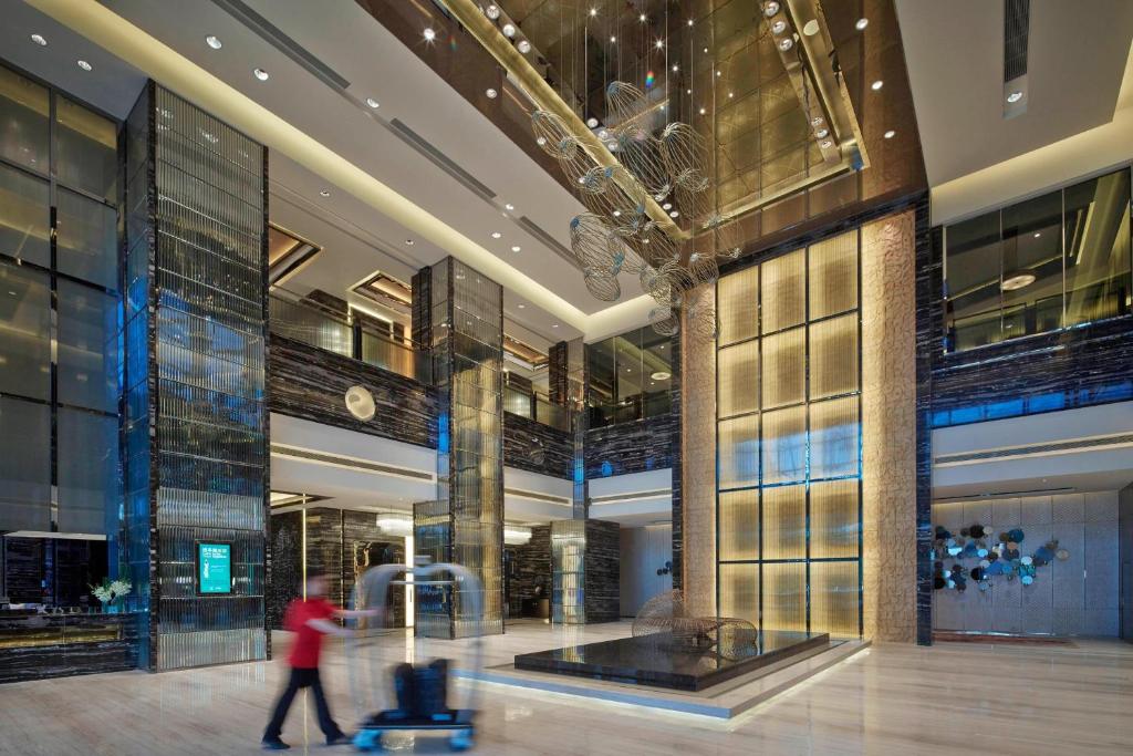 a person walking through a lobby of a building at Zhuzhou Marriott Hotel in Zhuzhou