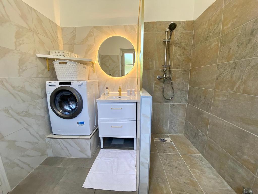 a bathroom with a washing machine and a washer at Le LOUIS 16 - Maison avec jardin in Valence