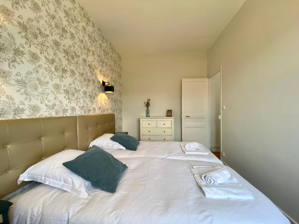 a bedroom with a white bed with blue pillows at Le LOUIS 16 - Maison avec jardin in Valence