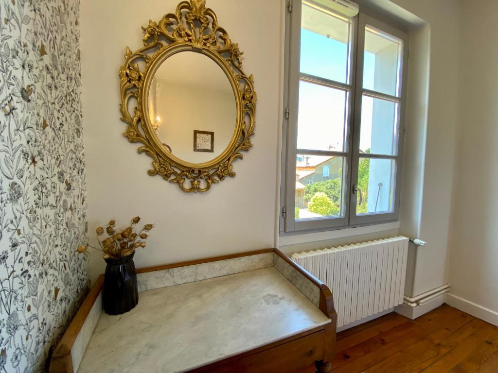 a mirror on a wall above a bench in a room at Le LOUIS 16 - Maison avec jardin in Valence