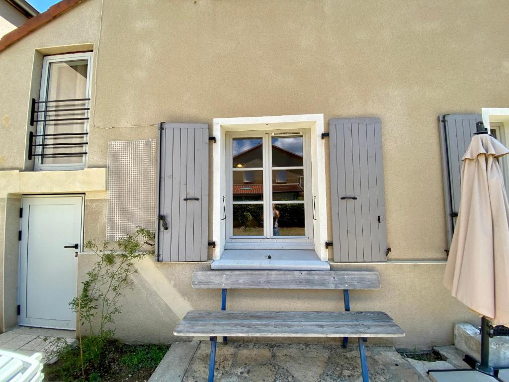 a building with two benches in front of a window at Le LOUIS 16 - Maison avec jardin in Valence