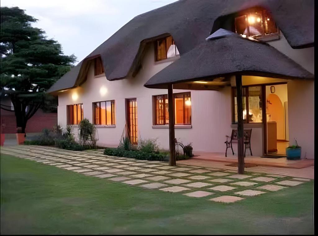 a house with a large umbrella in front of it at Manna House in Vereeniging