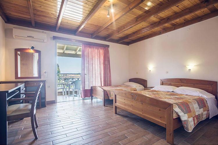 a bedroom with two beds and a balcony at Omirico Studios in Corfu Town