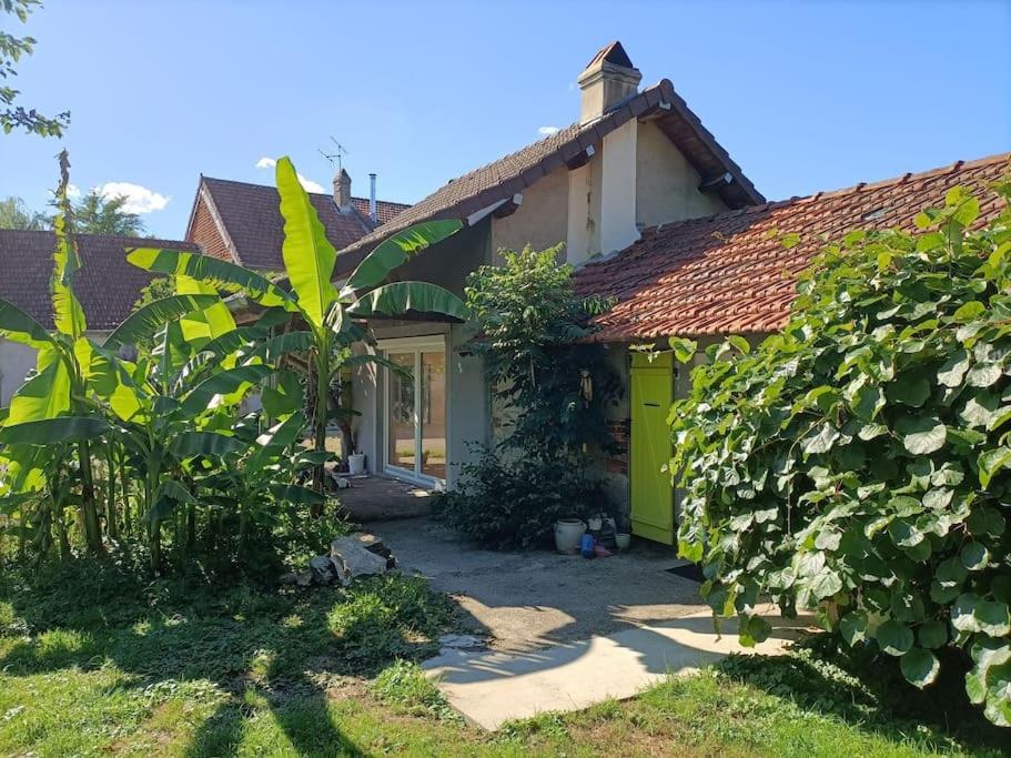 a small house with a yellow door in a yard at La Villa aux Bananiers 