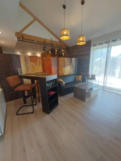 een woonkamer met een tafel en een bank bij Logement à 6 minutes du parc des expositions. in Chavagne