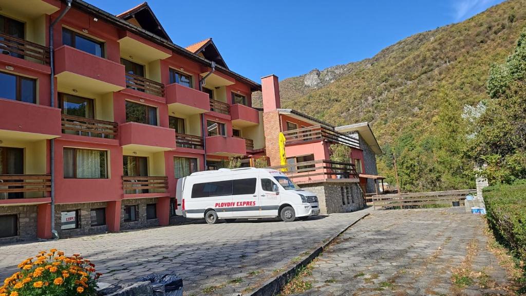 uma carrinha branca estacionada em frente a um edifício em Forest Spring em Asenovgrad