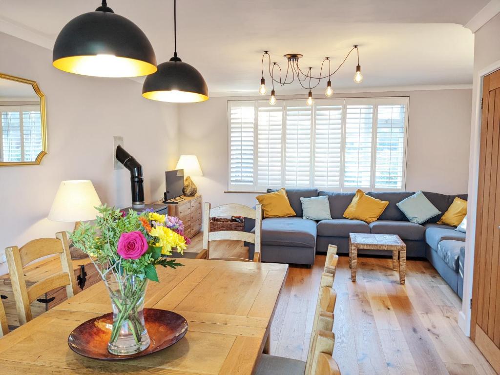 ein Wohnzimmer mit einem Tisch und einem blauen Sofa in der Unterkunft Sunny Days: Beautiful Spacious 4 bed house in Torquay