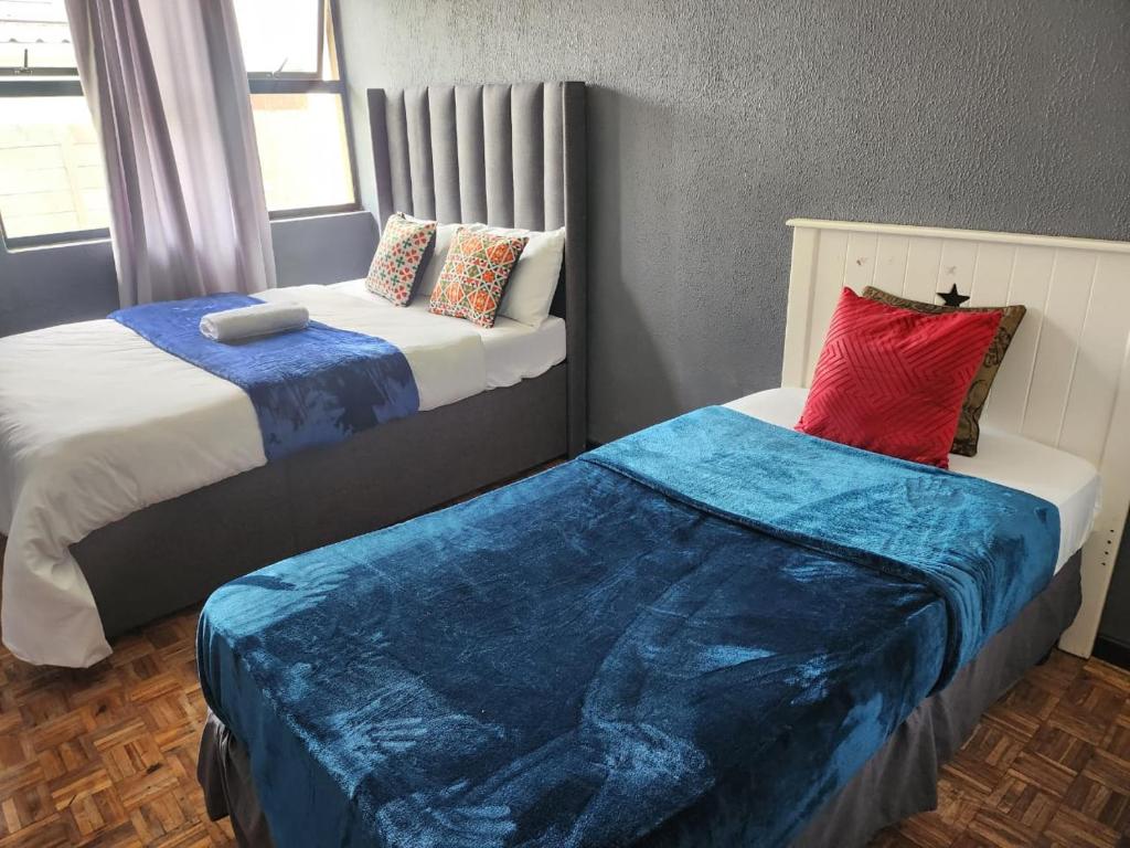 two beds sitting next to each other in a room at Ezcel accommodation in Cape Town