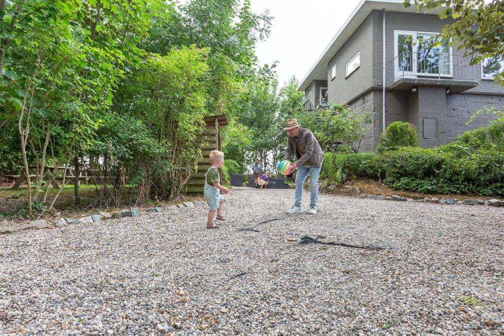 een man en een kleine jongen die met een frisbee spelen bij Zeeuwse Kustbunker in Groede