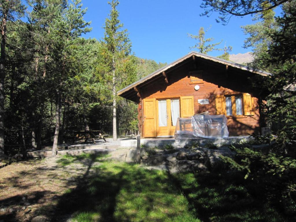 una cabaña de madera en el bosque con un patio en Chalet Le Mazet, 