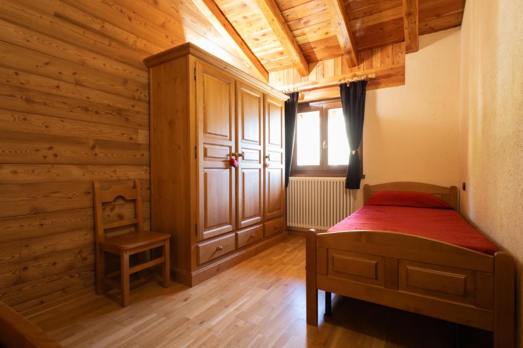 Leverogne RochefortMaison Godioz - Appartamento 7的一间卧室设有床、窗户和木墙