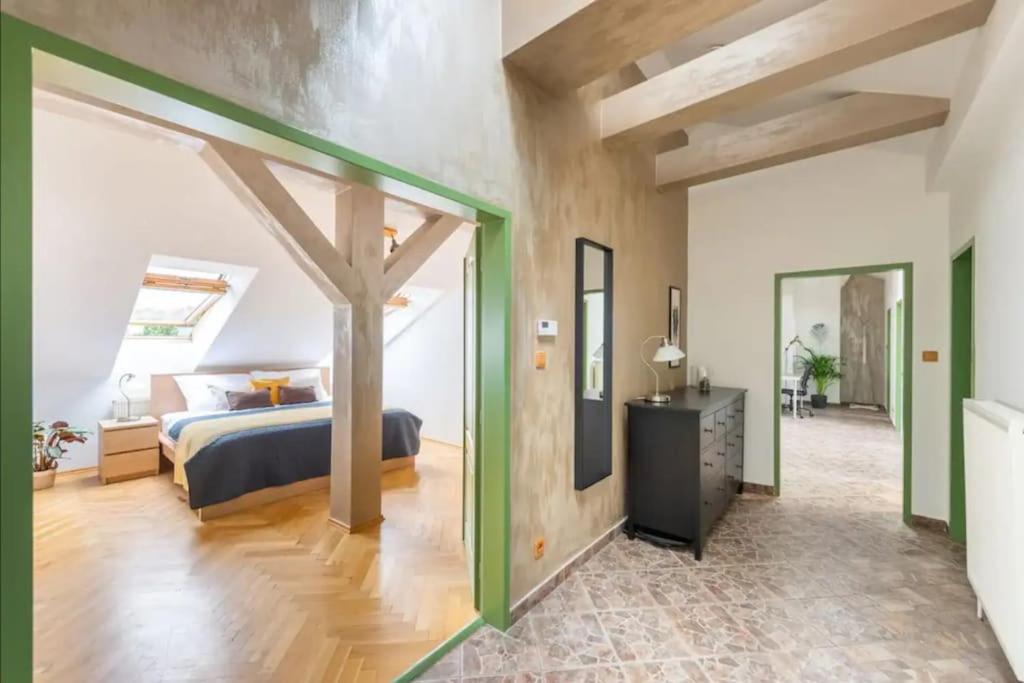 Huge 5-bedrooms apartment near Prague Castle في براغ: غرفة نوم مع سرير في غرفة مع لهجات خضراء