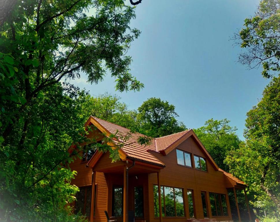 una casa con techo rojo y algunos árboles en HUNOR Vendégház, en Sátoraljaújhely