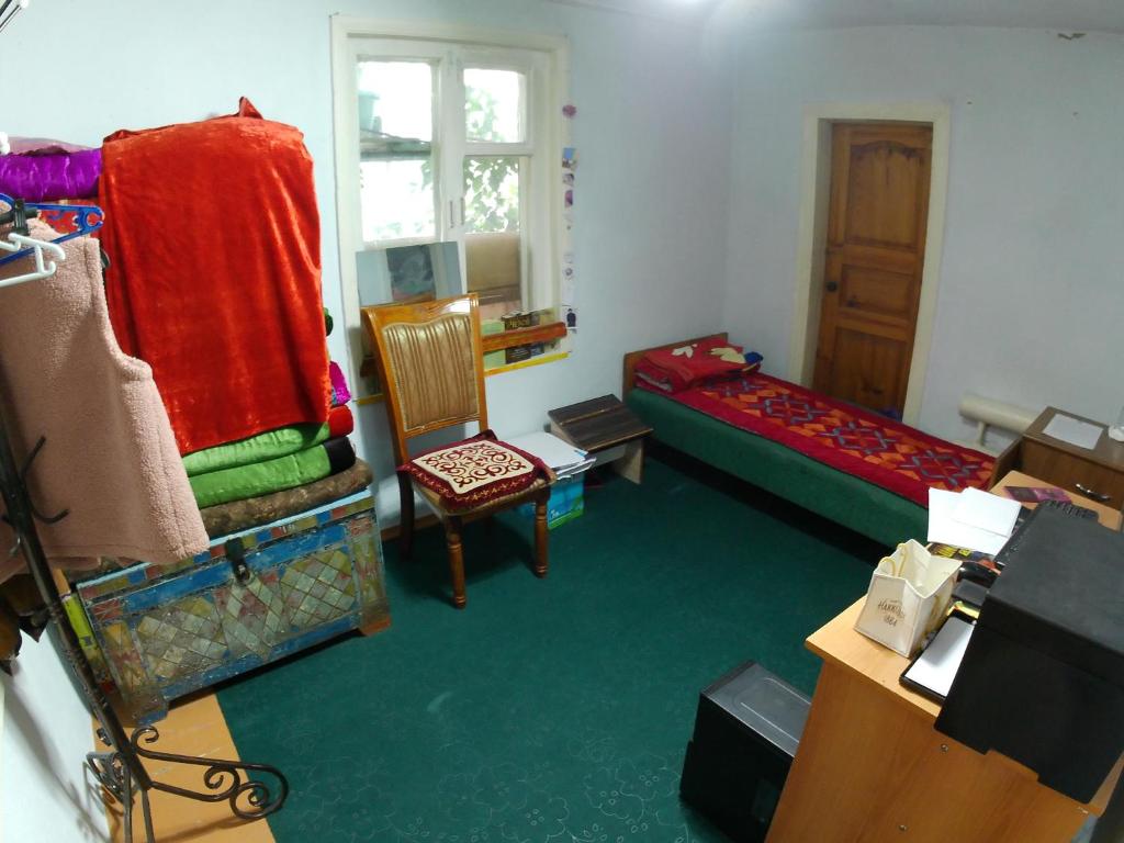 uma sala de estar com uma cama e uma cadeira em Zhany Borbor Nakta Bal 