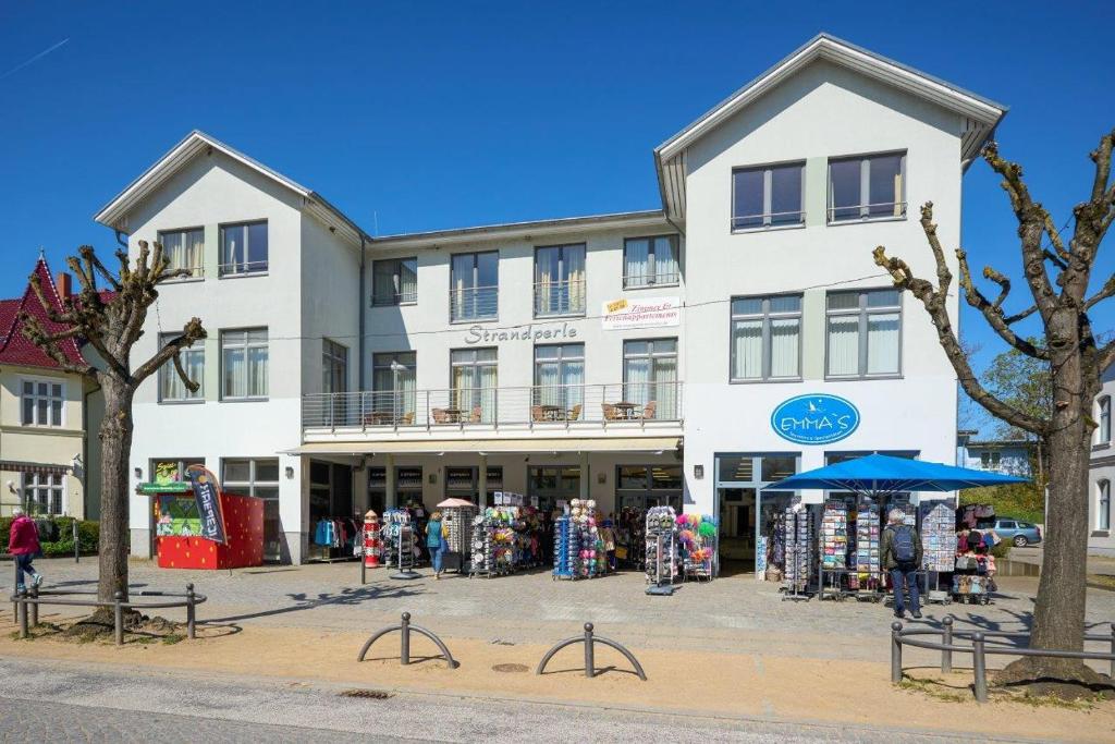 un gran edificio blanco con una tienda delante en Haus Strandperle, en Zinnowitz