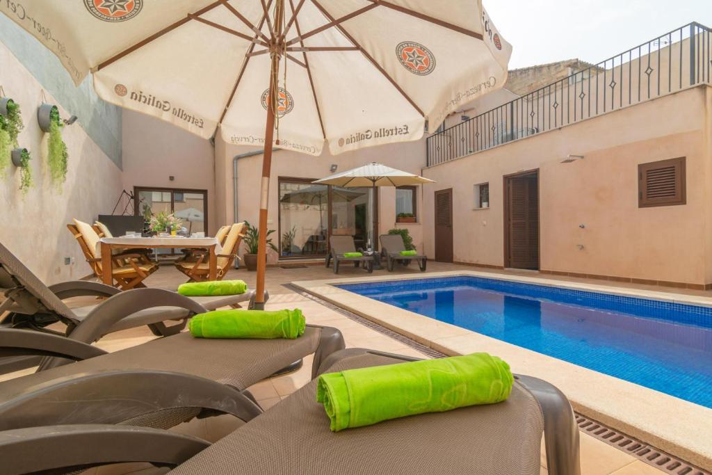 - une piscine avec des chaises et un parasol dans l'établissement Villa Placeta 6, à Sa Pobla