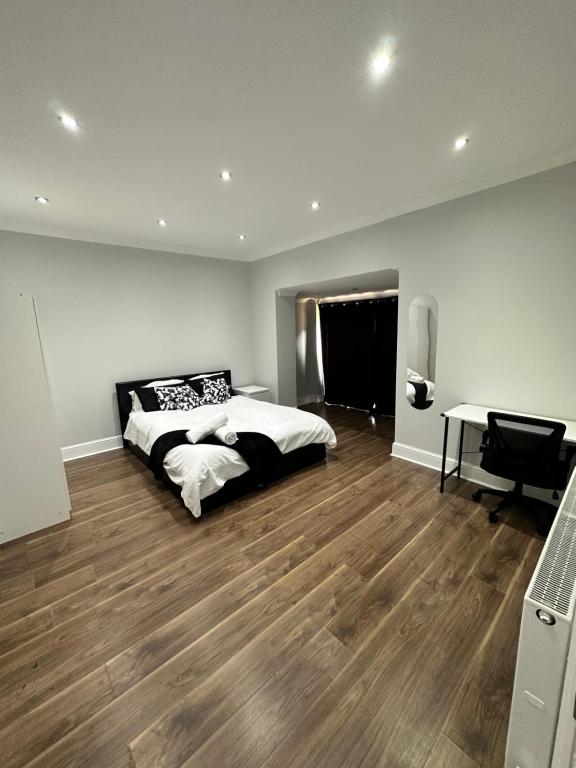 a bedroom with a bed and a desk in it at Black & White Double Bedroom in London