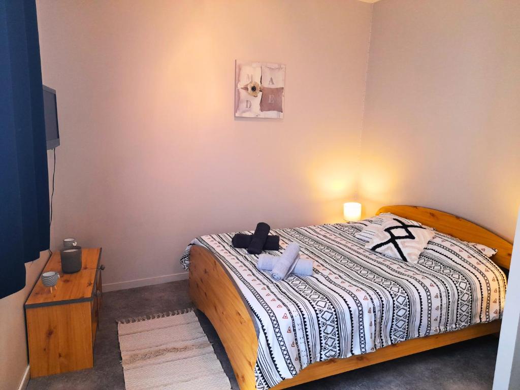 - une chambre avec un lit et une couverture noire et blanche dans l'établissement Le Cocon Beauvaisien - Hyper Centre - Wifi Fibre - TV HD, à Beauvais