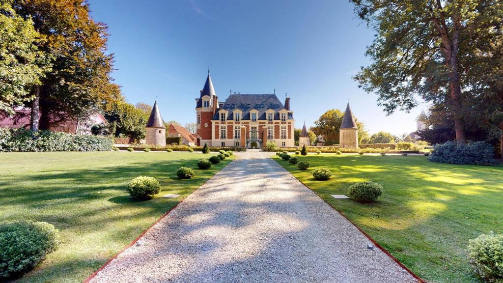 una entrada que conduce a una casa grande en un patio en Château de Bonaventure, en Aulnoy