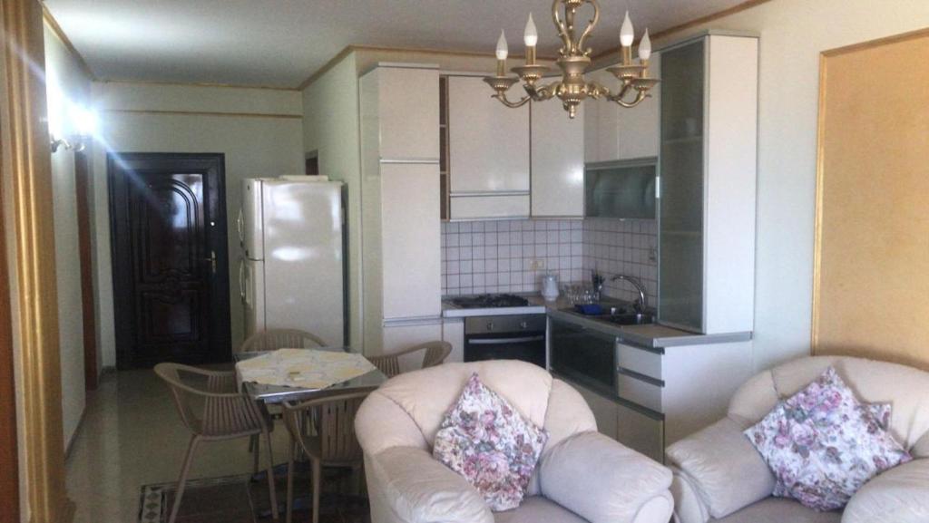 a kitchen with two chairs and a kitchen with a refrigerator at GOLD APARTMENTS in Durrës
